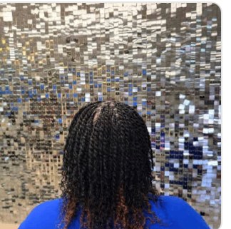 Knotless braids in front of the Signature Wall